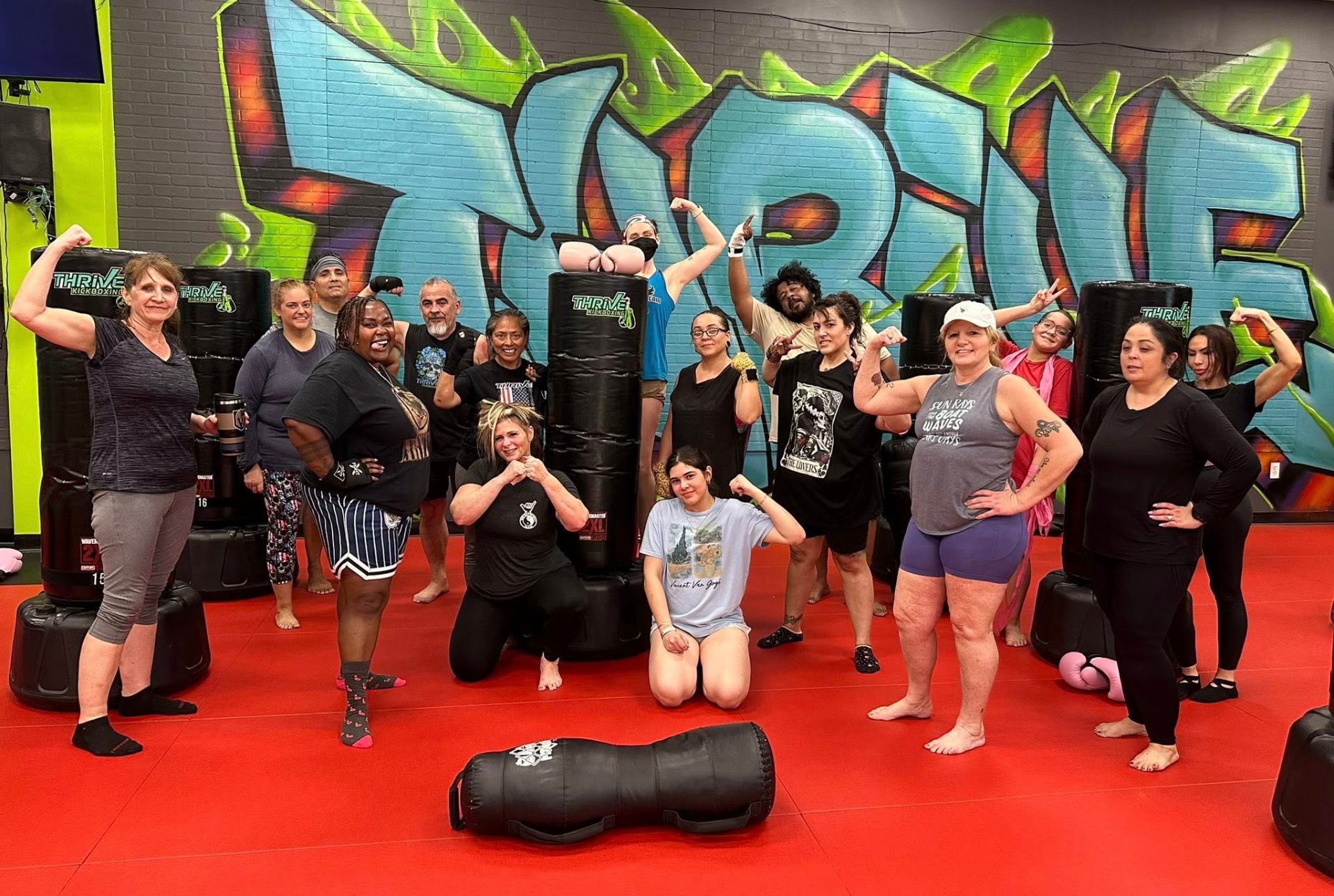 Thrive Kickboxing Henderson members posing together after class on the mat