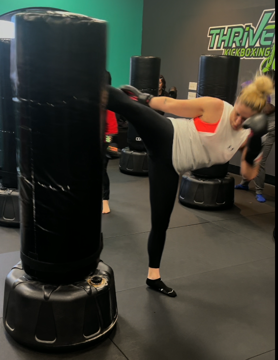Thrive Kickboxing member kicking heavy bag at Craig Road Northwest Las Vegas